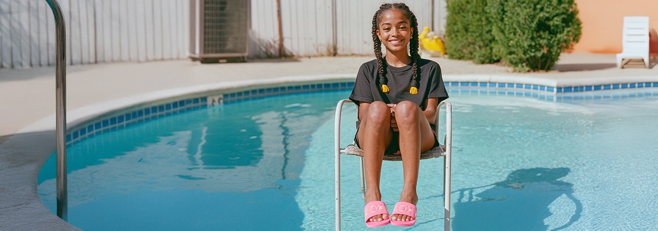 Girl sits on a chair in a pool and smiles