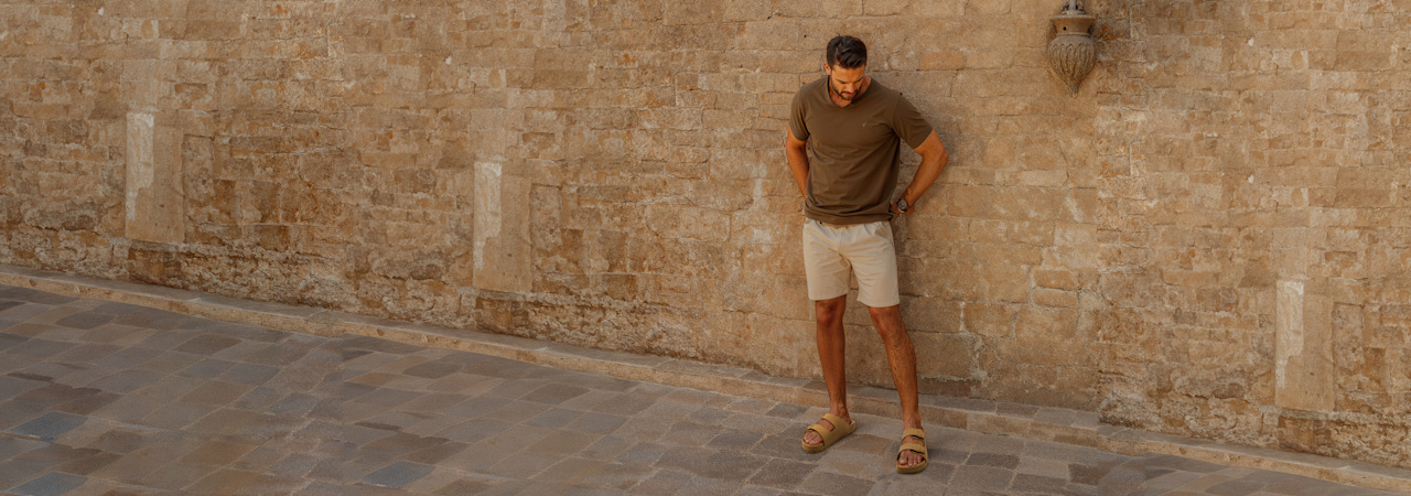 a man standing in front of an ancient wall