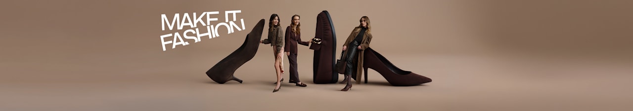 Fashion campaign image on a beige background featuring oversized dark brown loafers and high heels. Three models are posed around the shoes, wearing coordinated outfits in brown and neutral tones. The slogan “MAKE IT FASHION” appears in large white lettering in the upper left corner, highlighting a seasonal fashion footwear collection in chocolate brown shades.