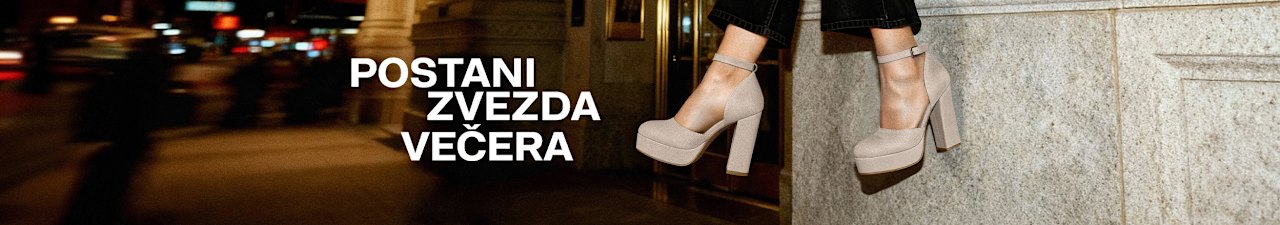 Close-up of beige high-heeled platform shoes worn with black pants, outdoors at night with blurred city lights in the background. Large white text reads: “POSTANI ZVEZDA VEČERA.”