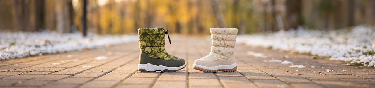 two snowboots standing on a path with snow