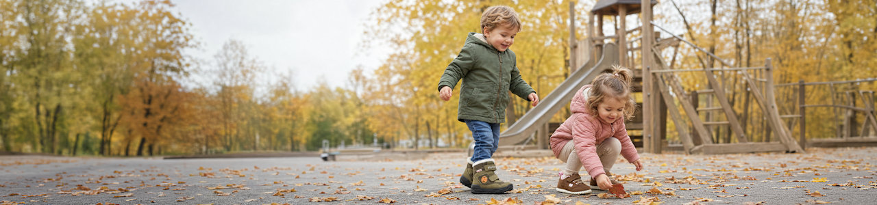 two kids playing on a playground in autumn