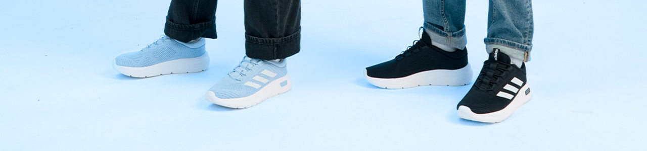Three people wearing Adidas sneakers: one in light blue with white stripes, one in light blue with grey stripes, and one in black with white stripes, all shown from the lower leg down.