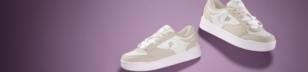 a pair of sandcolored fila sneakers