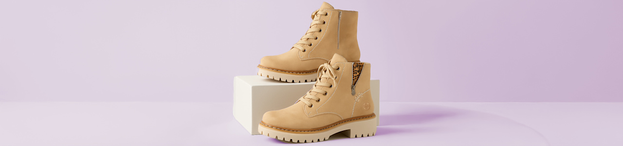 Two Boots in front of light purple background