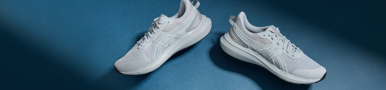 Two shoes in front of coloured background