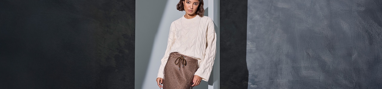women wearing a beige sweater and a brown skirt