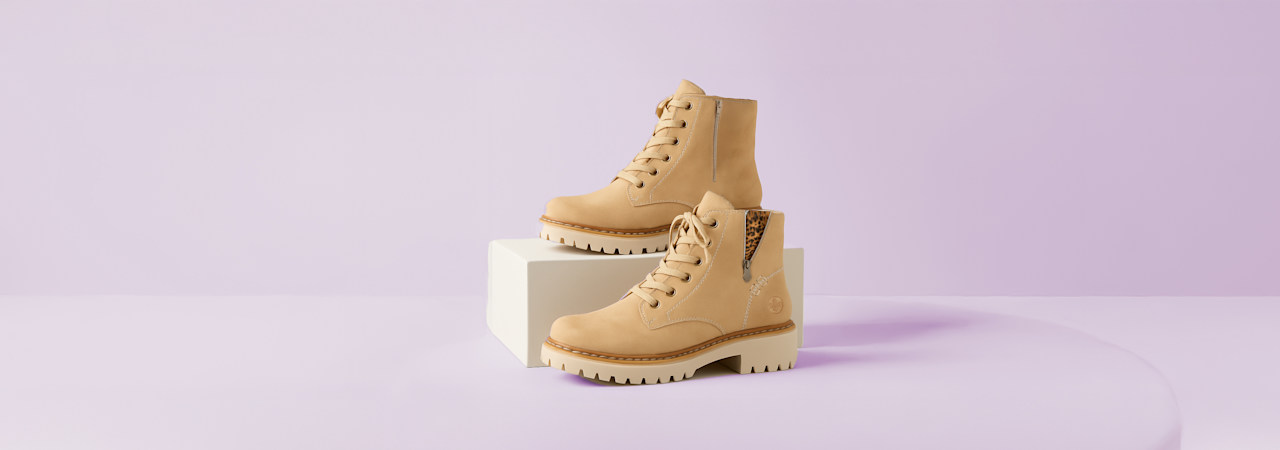 Two Boots in front of light purple background
