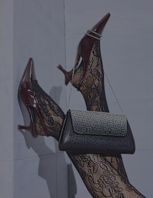 high heels on foot with a black glittering bag