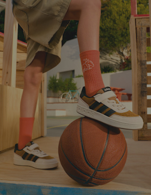 Adidas children’s shoes balanced on a basketball.