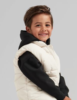 A boy in front of a grey background.