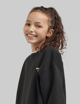 A teen girl in front of a grey background.