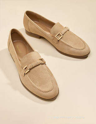Beige/brown loafers on beige background.