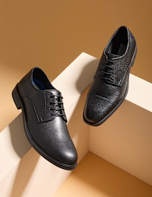 Mens business shoes in front of a brown background