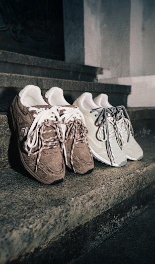 Close-up of two pairs of FILA sneakers displayed on stone steps. The shoes feature suede and mesh uppers in taupe and cream colorways, with layered panel details, oversized laces, and retro-inspired running silhouettes highlighted by dramatic evening lighting.