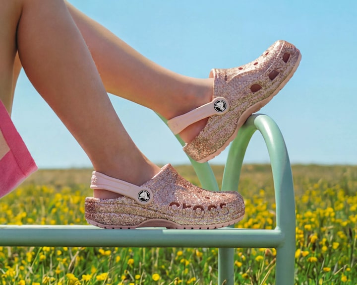 Close-up of pink clog-style shoes worn while standing on a metal frame.