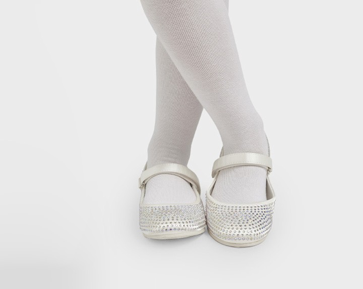 Female standing cross legged with ballerinas
