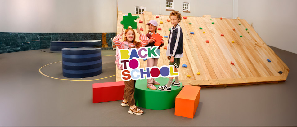 Children posing with a multilingual back-to-school display.