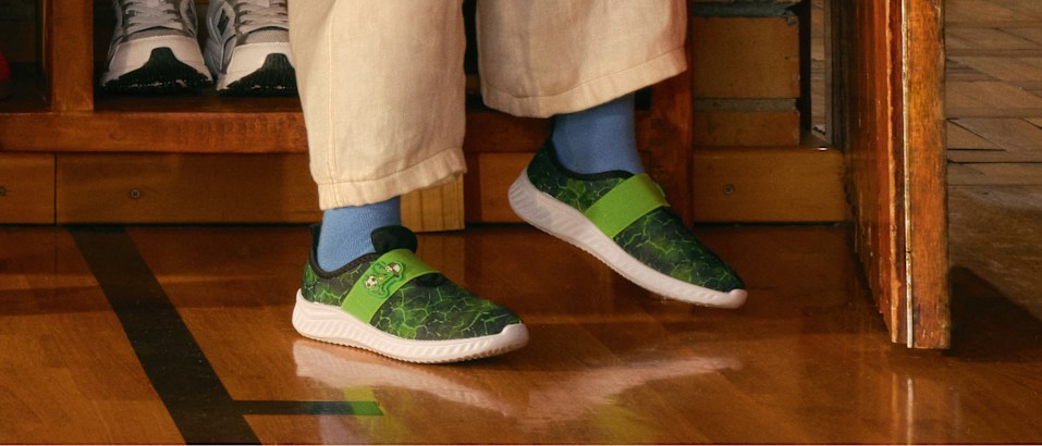 Green slip-on shoes worn indoors.