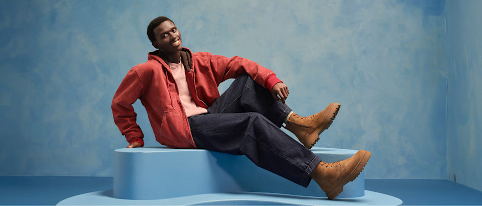men with boots sitting on a pedestal with blue background
