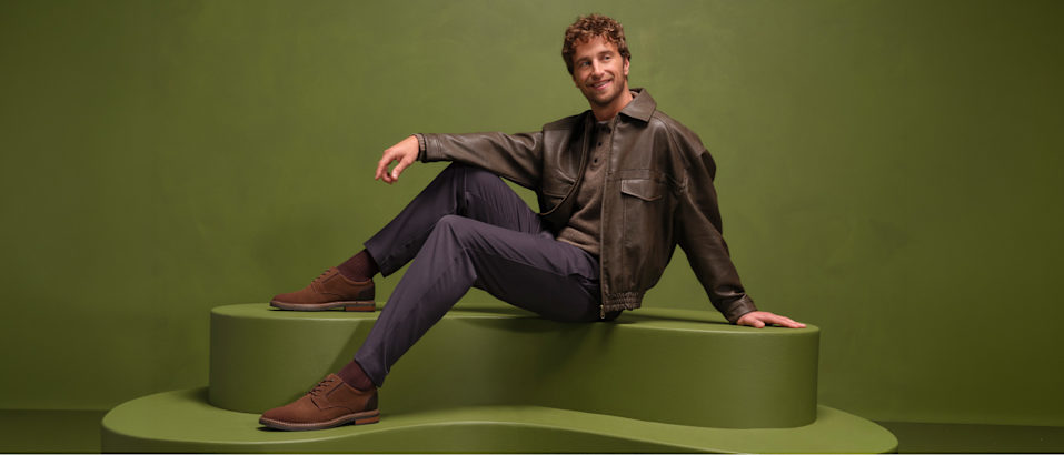 men with loafers sitting on a pedestal with green background