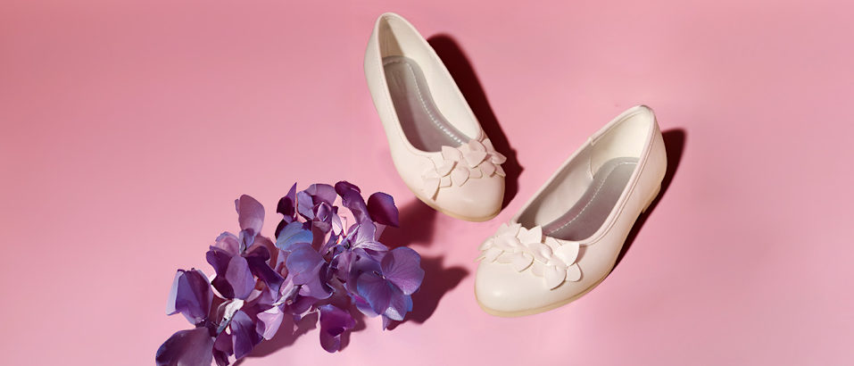 White ballerinas in front of pink background with purple flowers