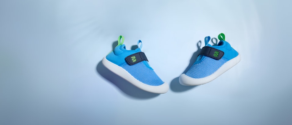 Blue toddler shoes in front of blue background